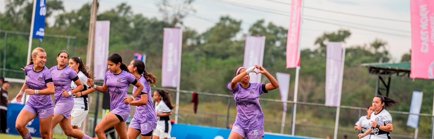 Giocatori giovanili in azione durante una partita di calcio in un parco sportivo a Paraguay